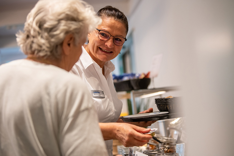 Patientin wird gedient von der Hotellerie Mitarbeiterin